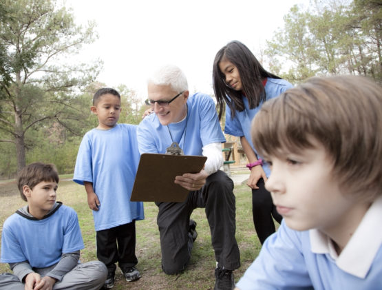 Older man coaching young children.