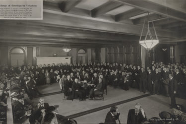 Ray Lyman Wilbur in Old Union amid a bank of phones