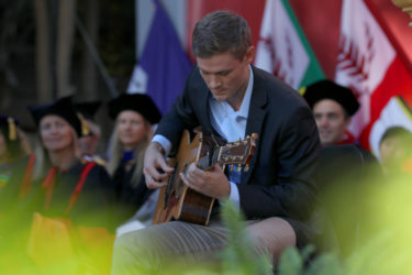 Kyle Tessier-Lavigne seated and playing guitar.