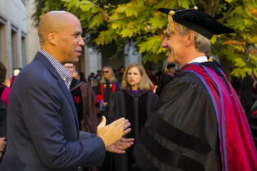 Corey Booker speaking as Marc Tessier-Lavigne listens.