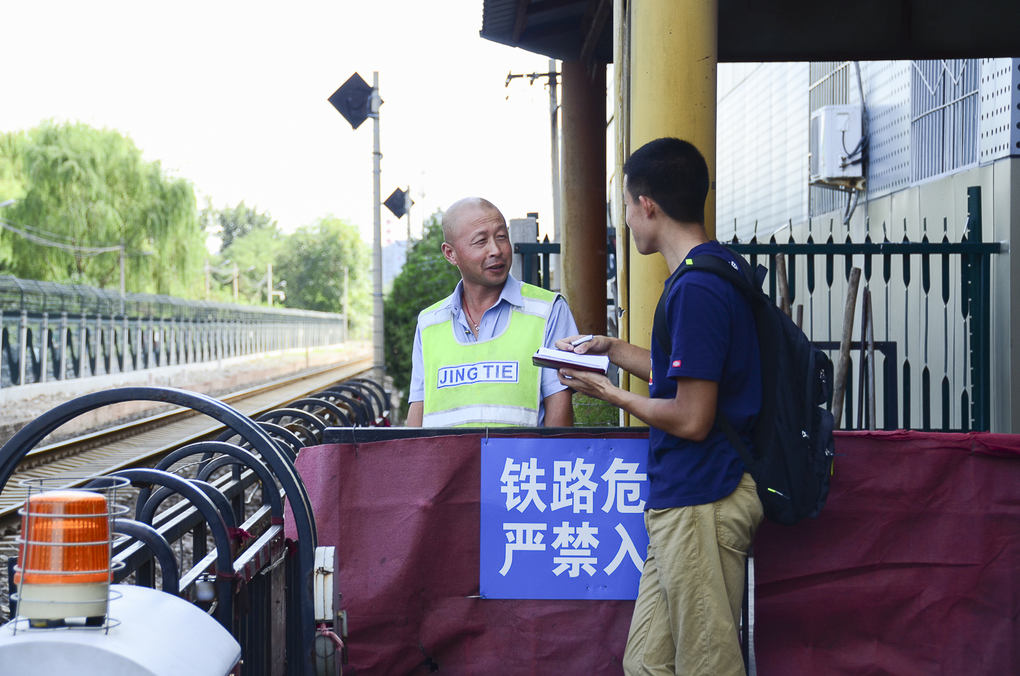 Student conducts fieldwork in Beijing by interviewing train station guard.