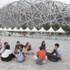 class sitting in discussion outside the Bird's Nest stadium at Olympic Village in Beijing