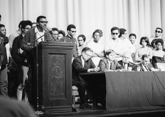 Members of the Black Student Union take the stage and microphone during a program following the assassination of Martin Luther King, Jr., April 8, 1968