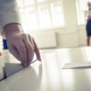 Hand of a person casting a ballot at a polling station during voting