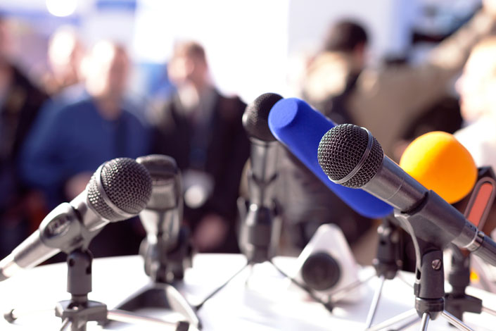 microphones set up on a lectern for a press conference