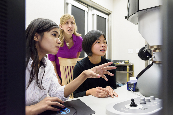 Fariah Hayee, Jen Dionne and Ai Leen Koh working at an electron microscope