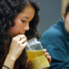 Student sipping through a straw a self-brewed beer from an ancient recipe