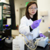 Chong Liu examines a carbon-amidoxime electrode before assembling it into the flow device.