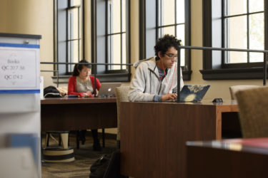 students work on laptop computers on tables in Li & Ma Science Library