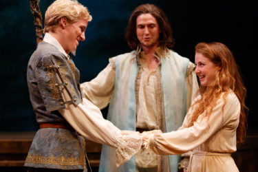 In a production of Shakespeare’s The Tempest, Miles Petrie and Emma Rothenberg are Ferdinand and Miranda, while Tim Schurz as Prospero looks on.