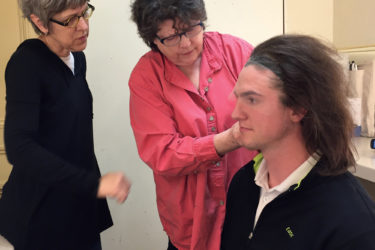 For a production of Shakespeare’s The Tempest, Costume designer Connie Strayer and wig designer Kerry Rider-Kuhn fit Prospero’s wig on Tim Schurz.