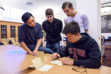 Junior Alexander Wang, T.A., grad student Peter Hick, senior Teun de Planque, and freshman Berber Jin examine a pamphlet on Martin Luther King, Jr. written by Mao Zedong.