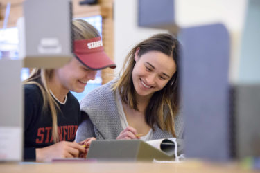 Senior Caroline Doyle and junior Jessie Dalman examine papers in the Barchas Room.