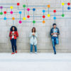 people standing against a wall interact with their phones; a graphic is superimposed to show their connections