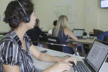 woman wearing headphones working on a laptop