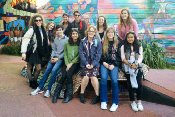 students in front of a mural in San Francisco's Mission District