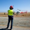 Person watches helicopter mapping groundwater