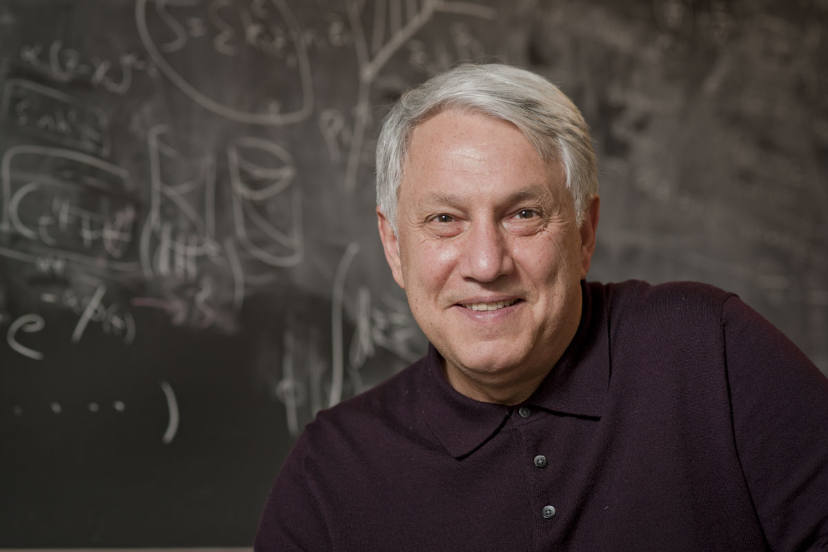 portrait of Andre Linde, professor of physics, in front of a blackboard of equations