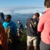 Instructor Zach Brown talking to students at the water's edge in rural Alaska