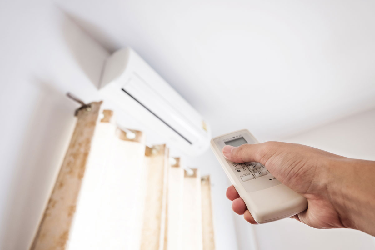 hand holding control to an airconditioning unit