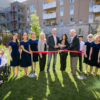 A group of children and adults cutting a ribbon