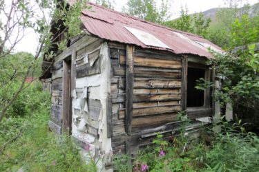 A cabin at Lower Rex Creek Camp with remnants of a canvas wind barrier.