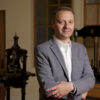 portrait of Alan Harvey, director of Stanford University Press, with old hand-operated printing presses in background