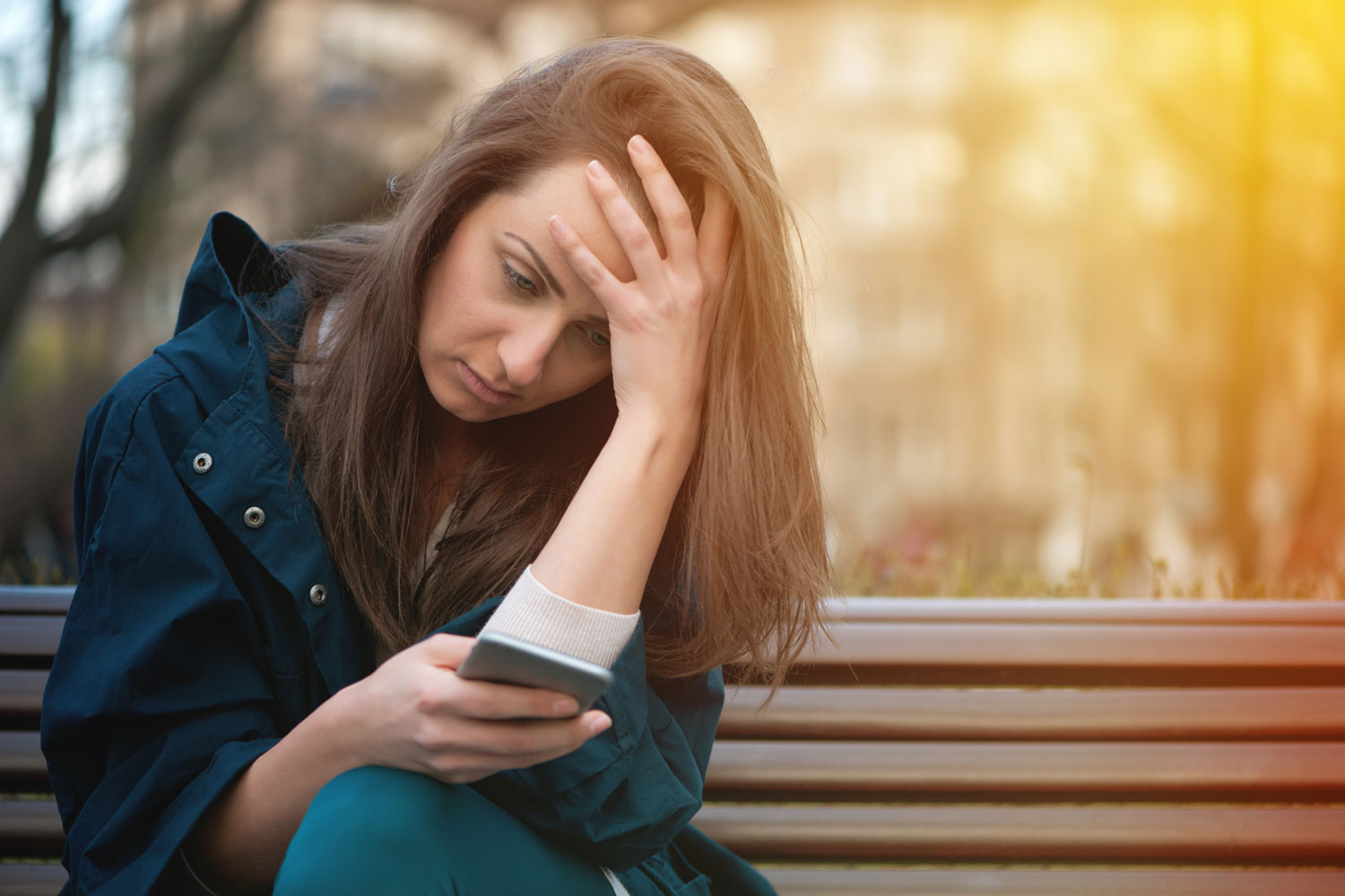 young woman on a bench looking at her cell phone