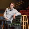 Branislav Jakovljevic sitting on a bench in a theater