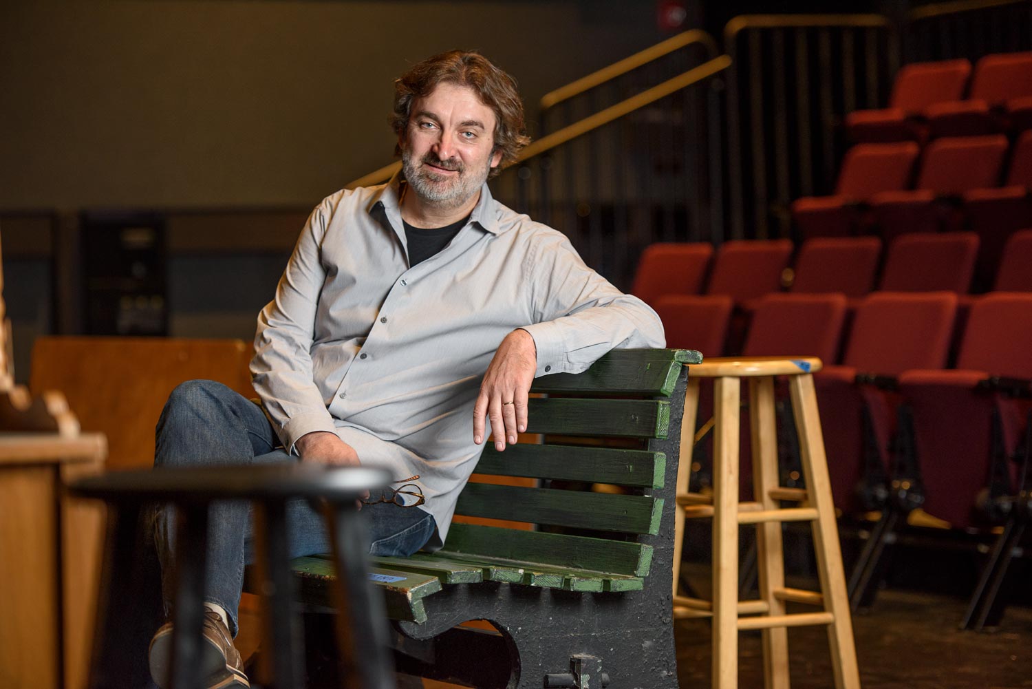 Branislav Jakovljevic sitting on a bench in a theater