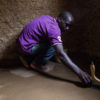 One of EarthEnable’s most experienced masons, Theophile Ngirukwayo, applies the company’s proprietary waterproof varnish to a home in Rwanda’s Bugesera District.