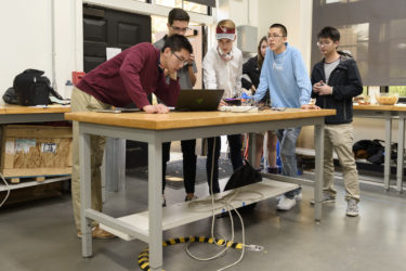 Students test each other's devices at the freshman haptics class open house.