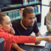 Small group of students working on computer in a library.