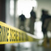 crime scene tape with blurred forensic law enforcement background in cinematic tone and copy space