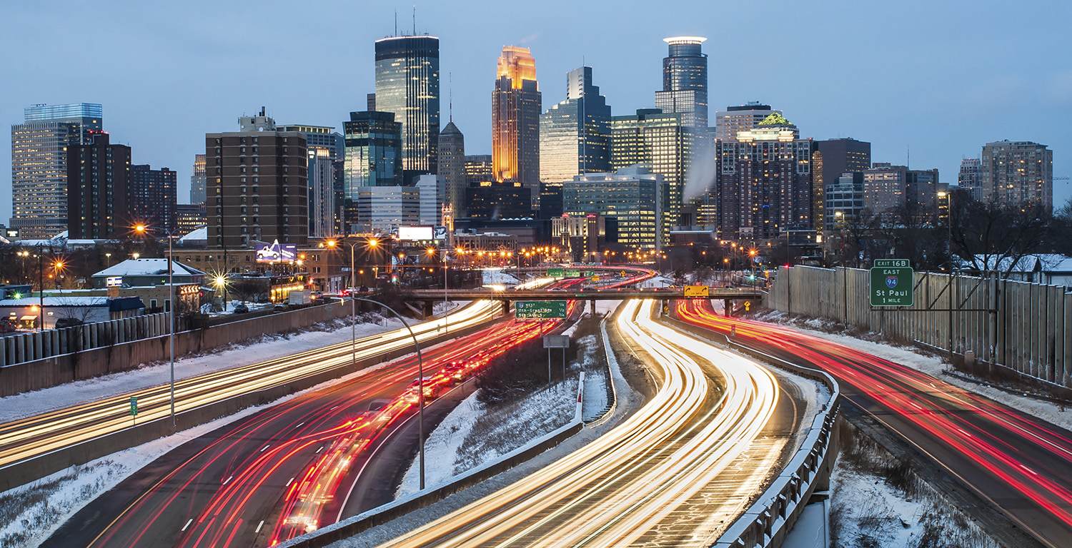 Heavy traffic flowing in and out of Minneapolis on Interstate 94 just after sunset, on a winter evening.