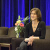 Judy Logan sitting next to a bouquet