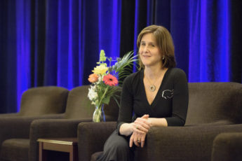 Judy Logan sitting next to a bouquet