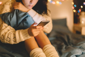 woman at home absorbed in her cell phone