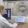 Doctor operating CT scanner in hospital