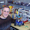 Steven Paley sitting at a work bench covered in engineering parts