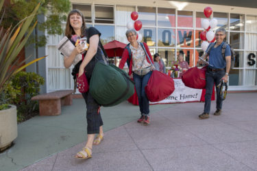 Sara Panzer gets a hand with her duffel bags from her parents, Emily Ghilarducci and Tim Panzer.