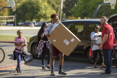 Freshman Yosheb Getachew of Parker, Colorado, carries some of his belongings to his dorm.