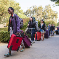 Some of the first students in line at FroSoCo make their way to the welcome table with their luggage in tow. Move-In Day. NSO 2016