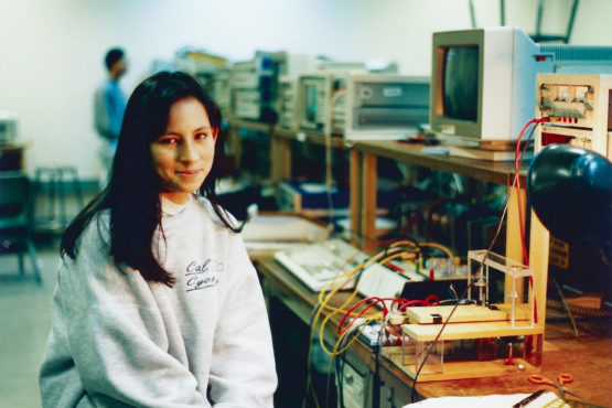 Okamura in a lab room sitting beside her project