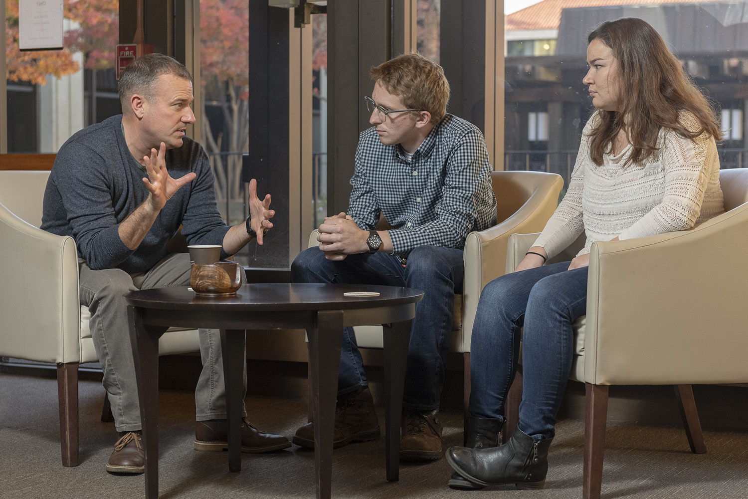 Lt. Col. Paul Krattiger meets with undergraduates Aidan J. Fay and Megan Haines.