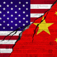 illustration of a crack in a brick wall painted with US and China flags