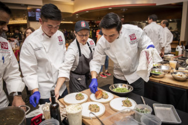 Marco Lorenzon, ’20, of Team Two plates his dish, “seared pork chop with parmigiano mushroom risotto.”