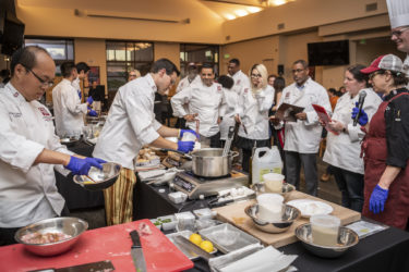 Team One chefs Scott Zhang and Vince Pane prepare their dishes as the judges look on.