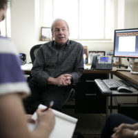 Psychology professor Ian Gotlib confers with students in his office.