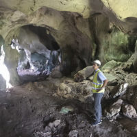 David standing inside a cave wearing a hard hat.